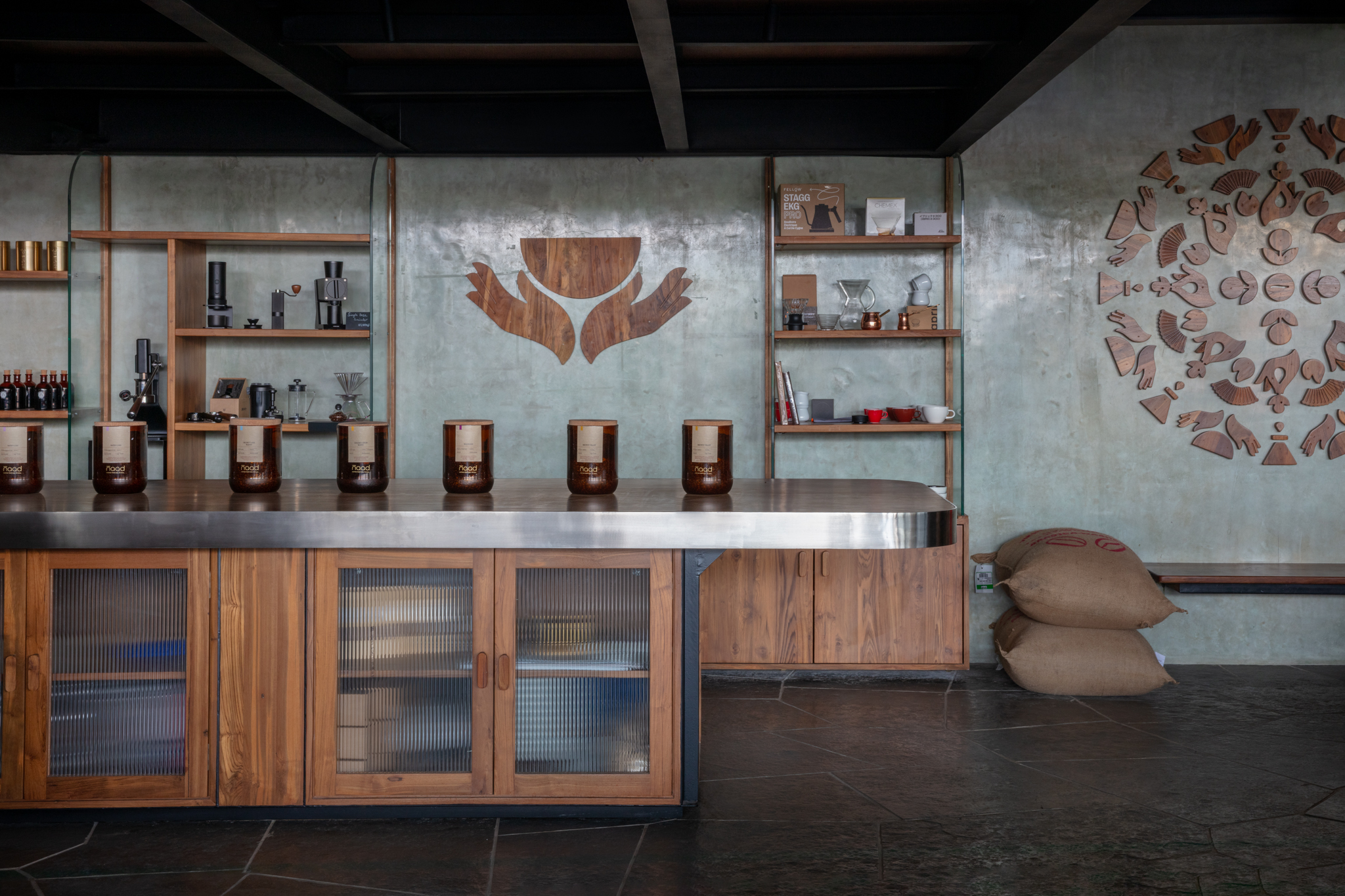 NAAD cafe counter with wood, concrete, coffee vessels and mandala wall installation